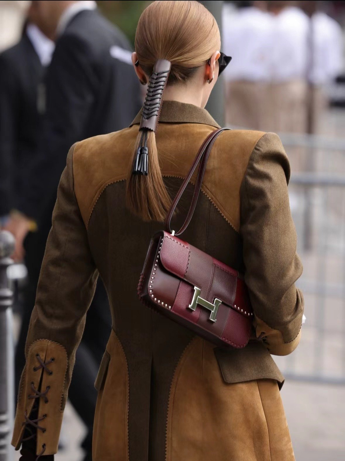 Burgundy shoulder bag styled with a brown coat